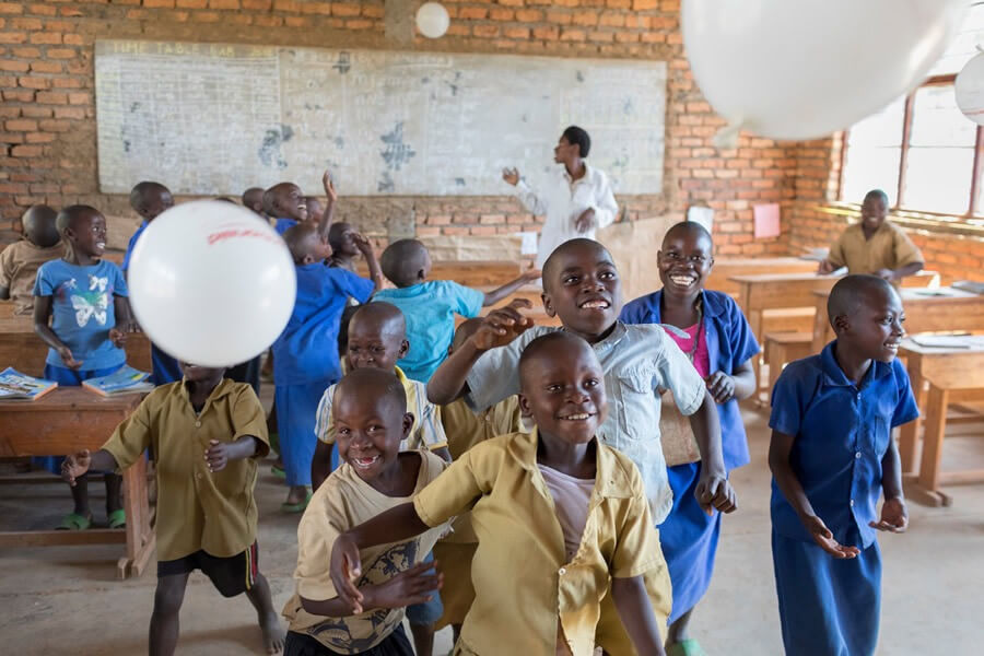 actionaid.gr παιδιά στην Αφρική σε τάξη παίζουν με ένα μπαλόνι